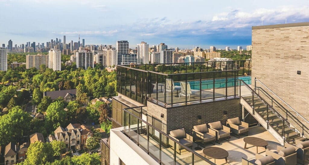 Multi-level rooftop terrace and swimming pool overlooking the lush tree canopy and downtown Toronto skyline at our boutique luxury apartments in Midtown.