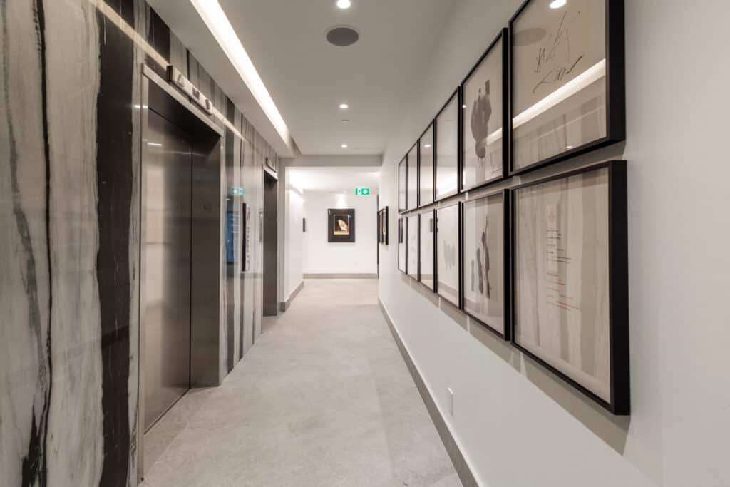 Elegant, double-height lobby enriched with carefully selected art pieces, custom bookshelves, and natural light at our Midtown Toronto luxury apartments.