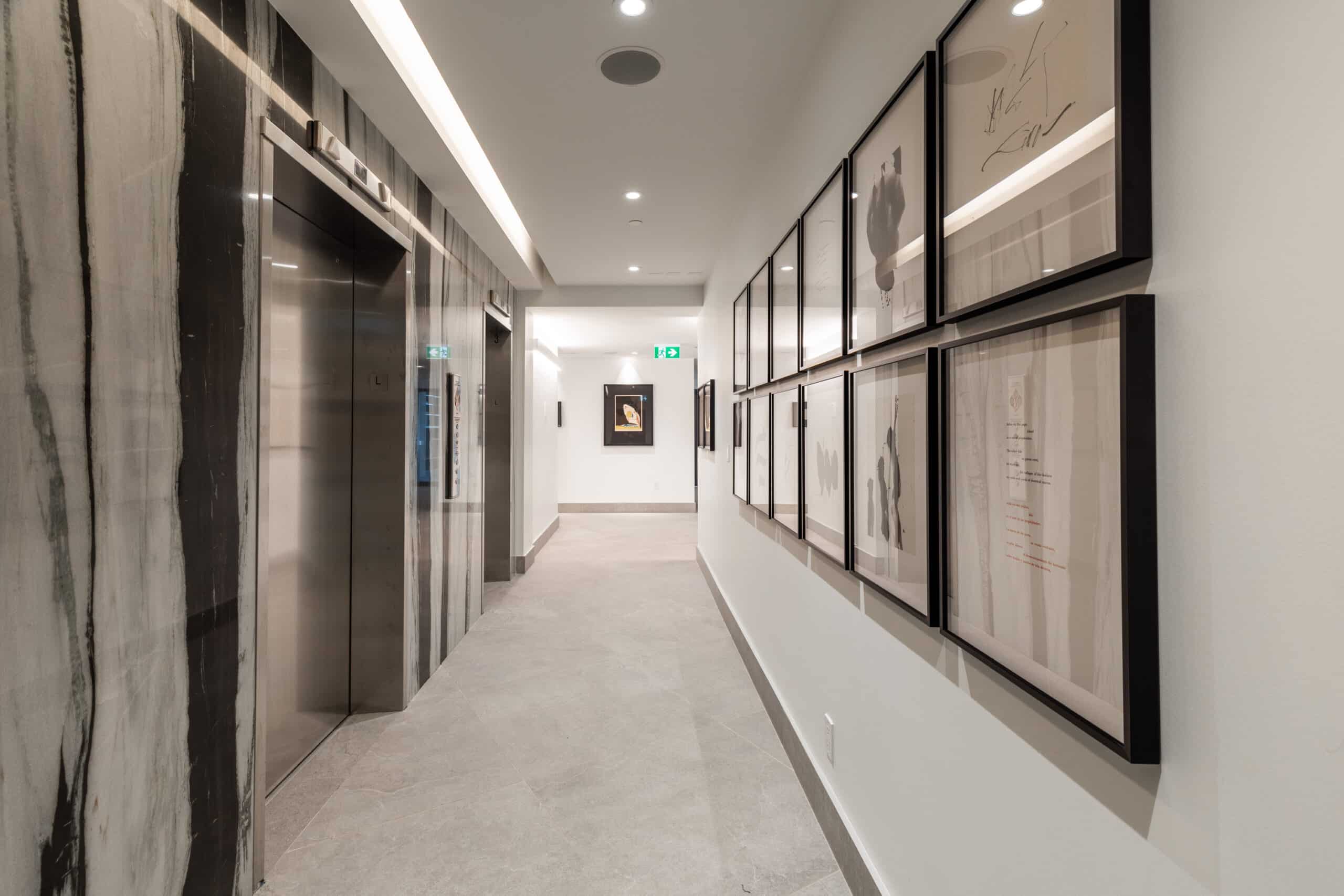 Elegant, double-height lobby enriched with carefully selected art pieces, custom bookshelves, and natural light at our Midtown Toronto luxury apartments.
