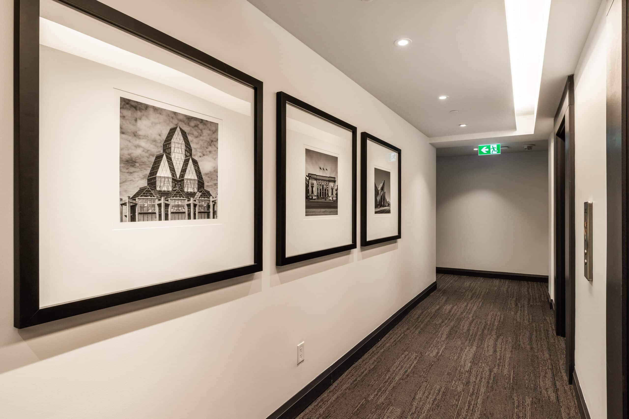 Modern elevator corridor showcasing a curated art collection and architectural photography at our premium luxury rental building in Toronto.