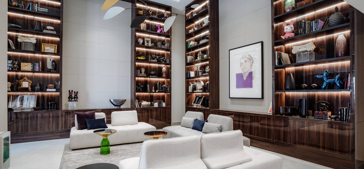 Elegant, double-height lobby enriched with carefully selected art pieces, custom bookshelves, and natural light at our Midtown Toronto luxury apartments.