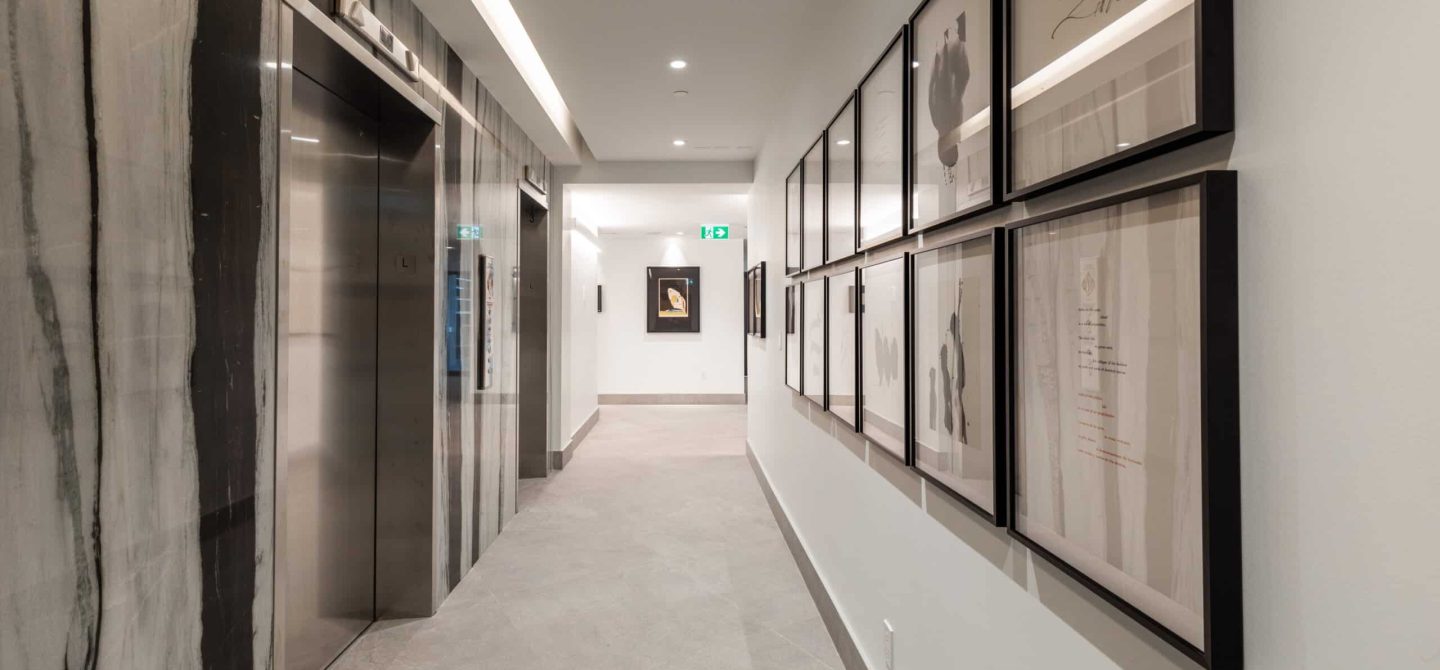 Gallery-inspired elevator lobby featuring curated black-and-white architectural prints, enhancing the boutique luxury rental experience at Yonge and Eglinton.