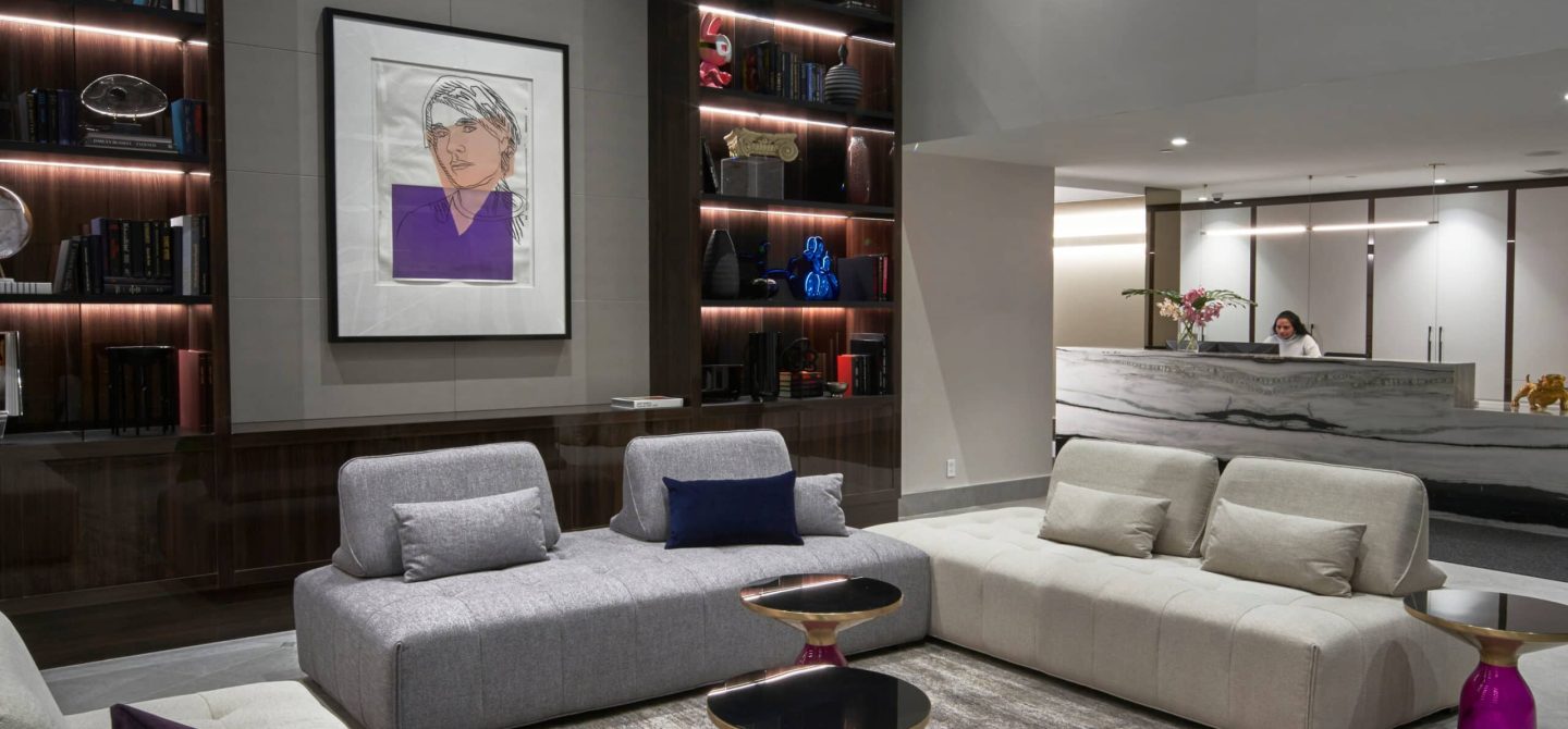 Welcoming resident lobby with a 24/7 concierge desk and sophisticated lounge seating at our Midtown Toronto luxury apartment building.